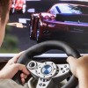 Teen playing in the race behind the wheel of a game console